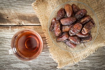 Wall Mural - Dried date fruit served with hot tea. Top view.  High nutrition fruit. Arabic favorite fruit.