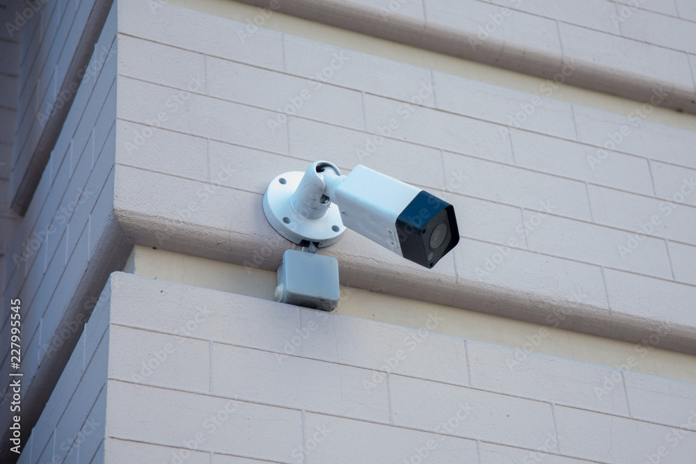 External surveillance camera mounted on the corner of a brick building ...