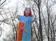 Maslenitsa effigy with the drawn person against the background of trees