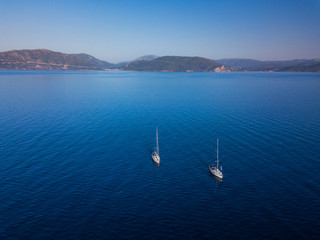 Aerial view to two Yachts in deep blue sea. Drone photography