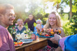 © jackfrog - cheerful family gathered around a table for a bbq in the garden