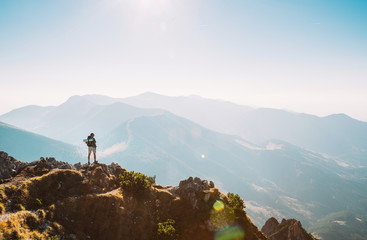 Mountain hiker with backpack tiny figurine stay on mountain peak with beautiful panorama