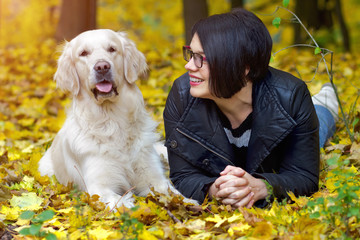 Portrait of happy woman with dog in autumn park.