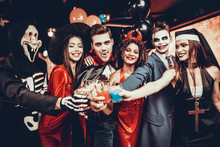 Friends In Halloween Costumes Drinking Cocktails