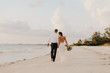 © MeganMahoneyPhotos - Perfect Sunset Destination Beach Wedding with Beautiful Bride and Groom Walking Down the Coastline