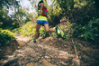 © lzf - Young woman trail runner running on tropical forest trail