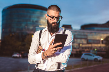 Portrait of a young caucasian businessman holding a digital tablet outdoor.