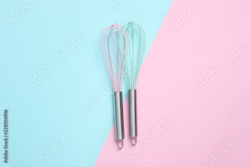 Fotomural Two whisk on blue pink pastel background. Top view, minimalism.