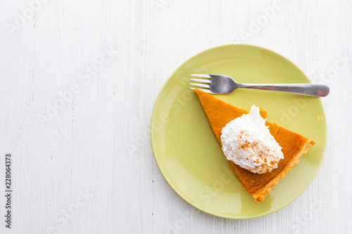 Fotografie, Obraz Slice of pumpkin pie with whipped cream over white wooden background