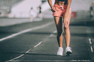 Wall Mural - Injuries - sports running knee injury on woman. Grey background