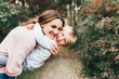 © galina_kovalenko - Mom and son hug and laugh in the autumn park. Space for text.