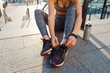 Woman ties shoelaces on sneakers