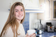 © OceanProd - smiling morning girl with tea time in home kitchen