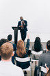 © LIGHTFIELD STUDIOS - african american lecturer talking to audience and gesturing during seminar in conference hall