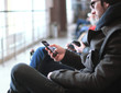 © yurolaitsalbert - close up.modern man with smartphone sitting in airport building