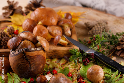 Fotografía Still life of mushrooms and forest flowers on wooden background .