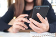 © Farknot Architect - Closeup image of a woman holding , using and looking at smart phone while working