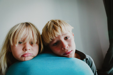 sad stressed little boy and girl hugging father, family in sorrow