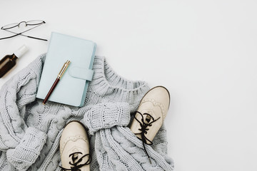 Flat lay of various cozy woman's clothes and accessories on white