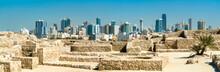 Ruins Of Bahrain Fort With Skyline Of Manama. A UNESCO World Heritage Site