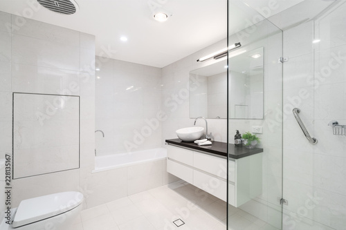 Large Modern Bathroom Interior With Floor To Ceiling Tiling And