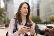 © blvdone - Business woman in city walking using cell phone