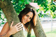 © ADDICTIVE STOCK - Playful happy brunette under green tree