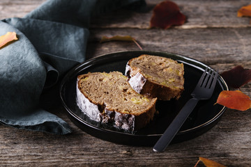 Wall Mural - Slices of homemade Apple Cinnamon Coffee Cake on a plate with orange autumn leaves on old rustic wooden table. Selective focus