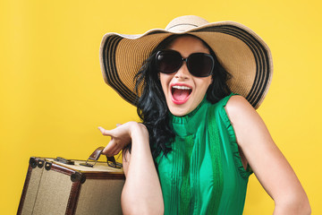 Wall Mural - Young woman with a suitcase travel theme on a yellow background