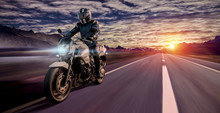 Motorcyclist Rides Home In The Evening On A Highway While Sunset