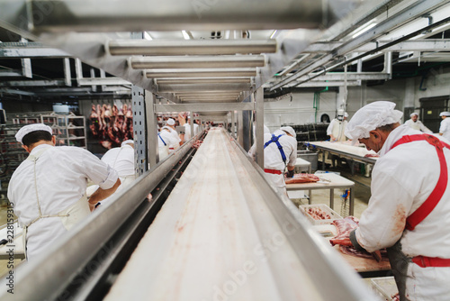 Fotografía Workers at meet industry handle meat organizing packing shipping loading at meat factory