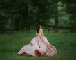© kharchenkoirina - girl in a long, rosy, waving dress runs into the forest. Frightened brunette girl looks around. Freedom, to escape from slavery. Art photo