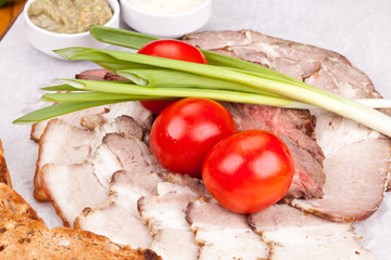 Wall Mural - Assorted cold meat with toasted bread, cherry tomatoes, onion and sauces on white plate. Close up