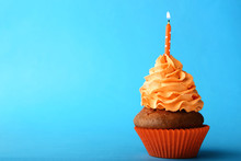 Tasty Cupcake With Candle On Blue Background