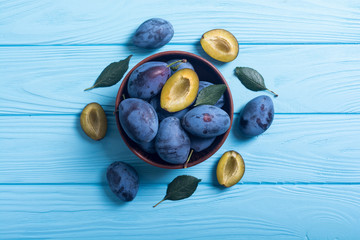 Canvas Print - Fresh plums in bowl on wooden table