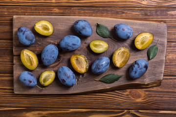 Canvas Print - Fresh plums in bowl on wooden table