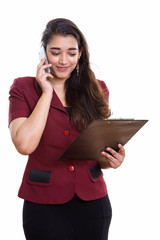 Wall Mural - Young beautiful Indian businesswoman reading on clipboard while 