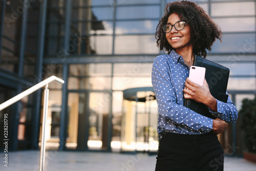 Happy business woman standing outside a office building Tableau sur Toile