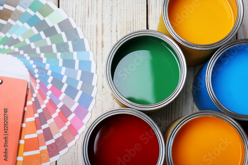 Fotografía Cans with paint and color palette on wooden background, top view