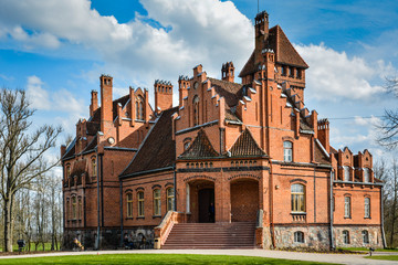 Jaunmoku castle near Tukums, Latvia on a clear sunny day. Beautiful blue sky and scenic clouds in the background. Postcard view. Shot in April 2015.