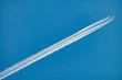 A long trail of jet plane on blue sky background.