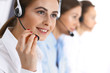 © rogerphoto - Call center. Group of operators at work. Focus on beautiful business woman in headset