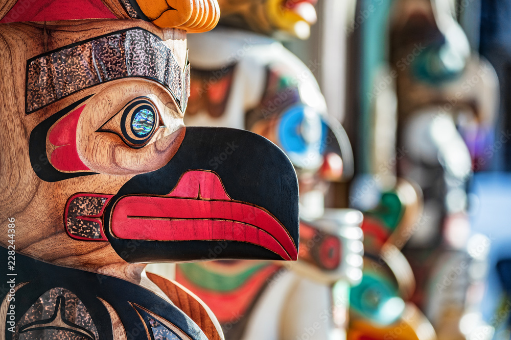Alaska totem pole carving art sculture store in tourist travel attraction town on Alaska cruise. Ketchikan, Juneau, Skagway stores and shops selling native paintings and art. - obrazy, fototapety, plakaty 