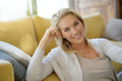 © goodluz - Portrait of attractive blond woman relaxing in sofa