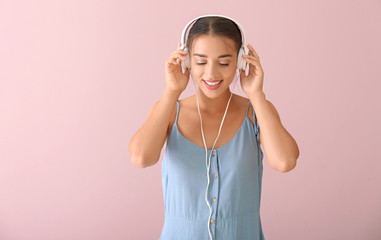 Poster - Beautiful young woman listening to music on color background