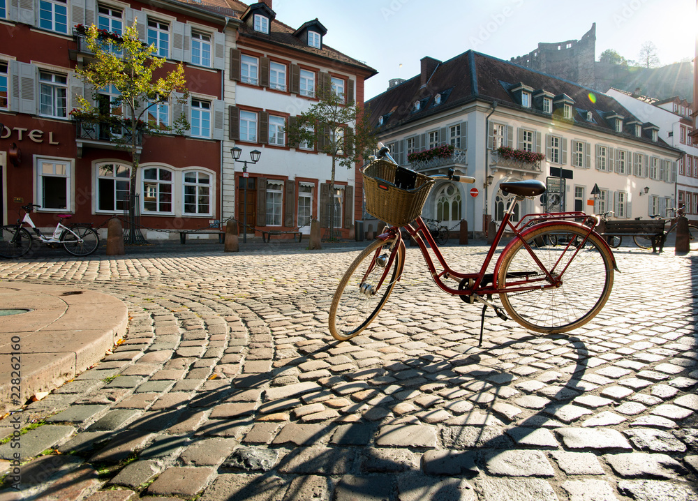 Heidelberg Altstadt, Fahhrad mit Korb im Sonnengegenlicht,  früh am Morgen mit langem Schatten - obrazy, fototapety, plakaty 
