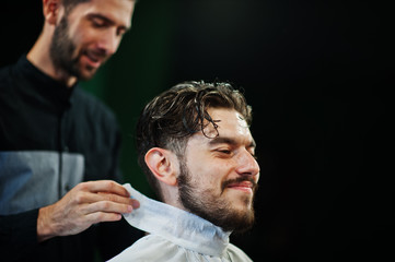 Wall Mural - Handsome bearded man at the barbershop, barber at work.