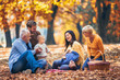 © Mediteraneo - Multl generation family in autumn park having fun
