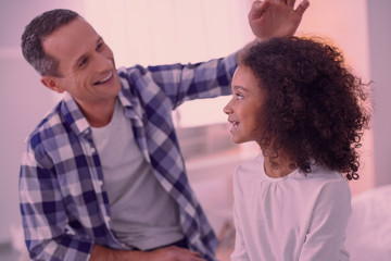 Wall Mural - With my dad. Joyful delighted girl smiling to her father while staying with his at home