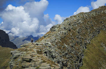 Fototapete - A hiker on a ridge in the Ticino mountains, Switzerland.